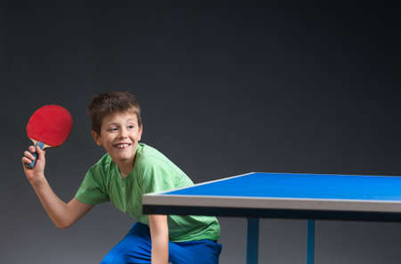 young boy playing table tennisの写真素材