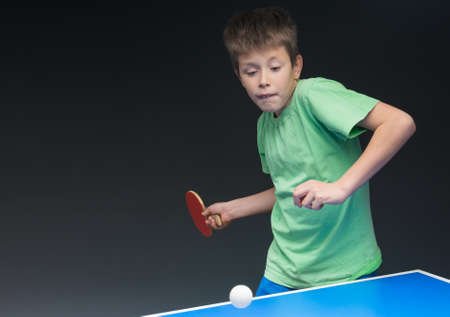 young boy playing table tennisの写真素材