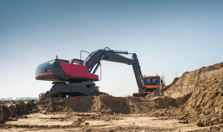 Hydraulic excavator and truck at work.の写真素材
