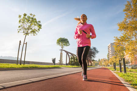 A young girl running outdoors in cityの写真素材