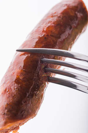 Fresh baked sausage on forkの写真素材