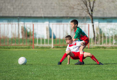 boys kicking football on the sports fieldの写真素材