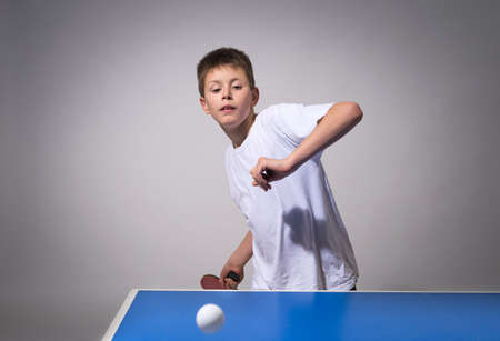 little boy playing table tennisの写真素材