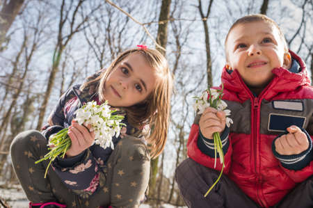 Boy and girl picking flowers of spring