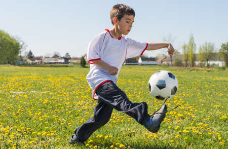 Boys kicking football on the  fieldの写真素材