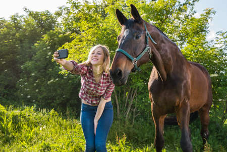 girl taking a selfie with his horseの写真素材