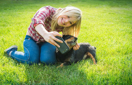 girl taking a selfie with his dogの写真素材