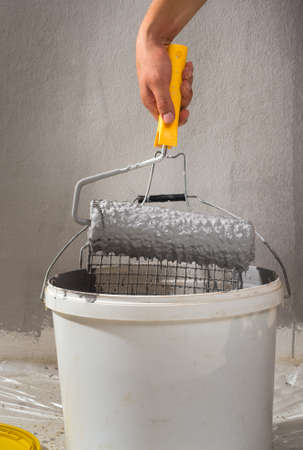 man colouring the wall with rollerの写真素材