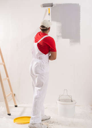 Young Man On Painting Wall With Rollerの写真素材