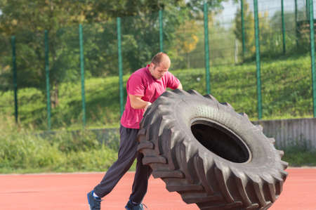 Young man does strongman exerciseの写真素材
