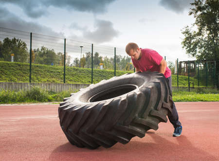 Young man does strongman exerciseの写真素材