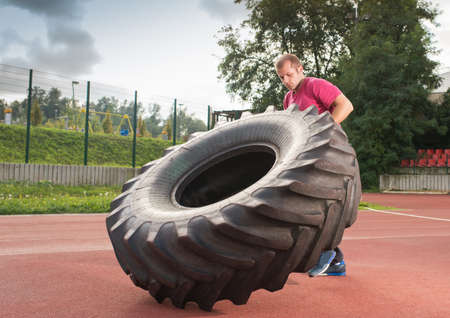 Young man does strongman exerciseの写真素材