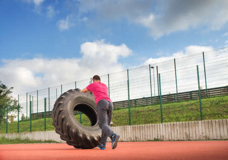 Young man does strongman exerciseの写真素材