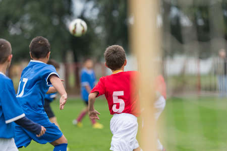 boy kicking football on the sports fieldの写真素材
