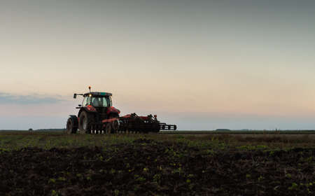 Tractor plowing a field at dusk