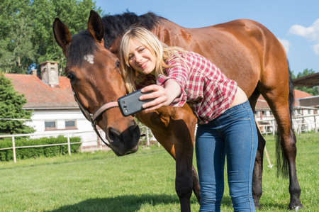 girl taking a selfie with his horseの写真素材