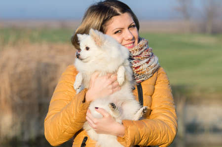 Happy girl with her little dog in natureの写真素材