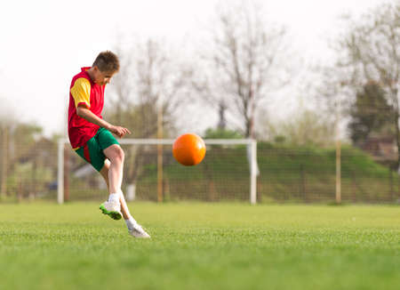 boys kicking football on the sports fieldの写真素材