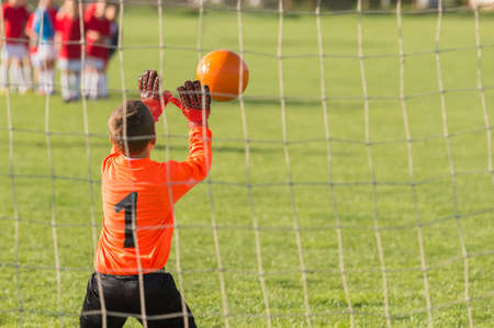 boy goalkeeper defends the goalの写真素材