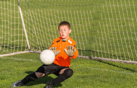 boy goalkeeper defends the goalの写真素材