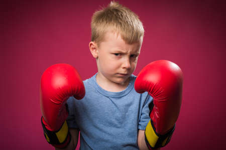 Little boy wearing red boxing glovesの写真素材