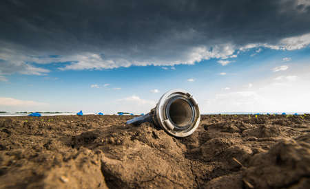 Very dry land - drought - and hose for watering