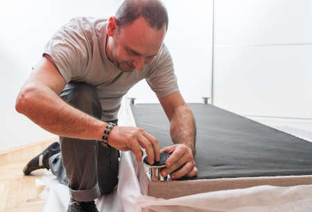 Furniture maker sets bed in bedroomの写真素材