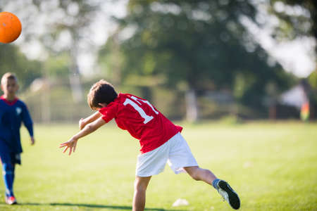 Young boy soccer player throws out the ball on the matchの写真素材