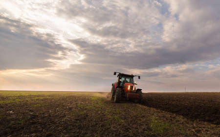 tractor plowing a field at duskの写真素材