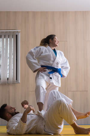 Young woman and man judo fighters in sport hall
