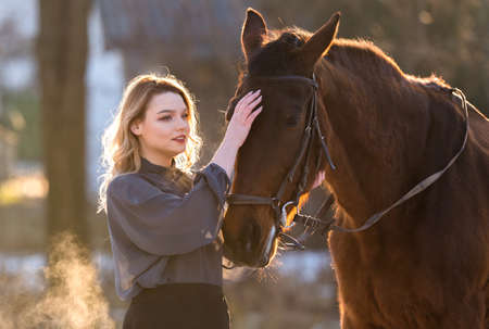 Young beautiful elegance modern woman posing with horseの写真素材