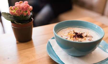 Delicious nutritious and healthy oatmeal with dried fruits on antique wood table