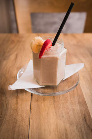 Fresh milk, strawberry and banana smoothie drink on wodeen table - assorted protein cocktail with fresh fruitsの写真素材