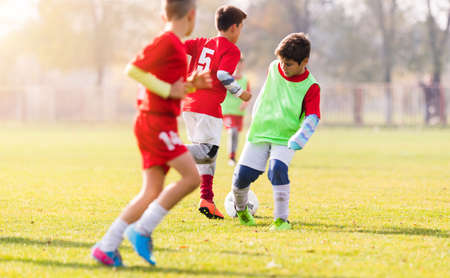 Boy kicking football on the sports field during soccer matchのeditorial素材