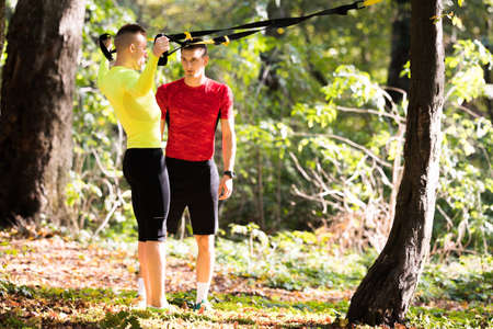 Handsome young men wearing sportswear and exercising in forest at mountain during autumnの写真素材