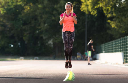 Young pretty girl doing exercises at sport fields