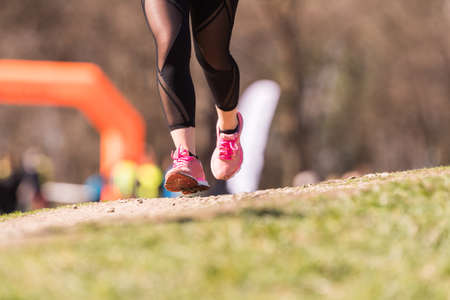 Marathon running race, people feet on grass road