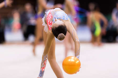 Girl in beautiful gymnastic dress doing exerciseの写真素材