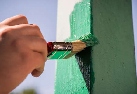 Men is painting metal surface with a brushの写真素材