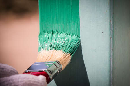 Men is painting metal surface with a brushの写真素材