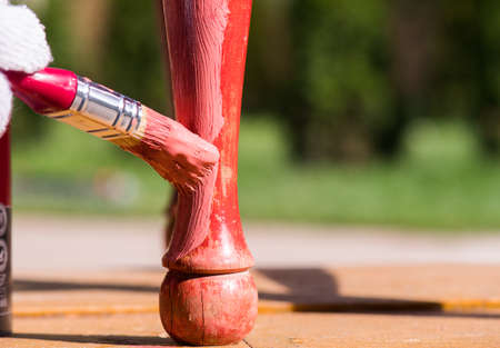 Worker is painting wooden chair with a brushの写真素材