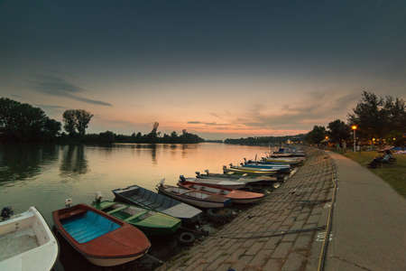 Anchored boats on a river bank at sunsetのeditorial素材