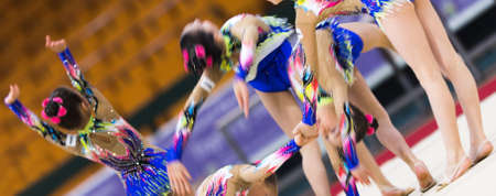 Girls in beautiful gymnastic dresses doing exercise