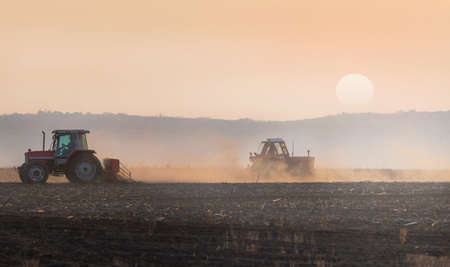 Tractors plowing stubble fieldsのeditorial素材