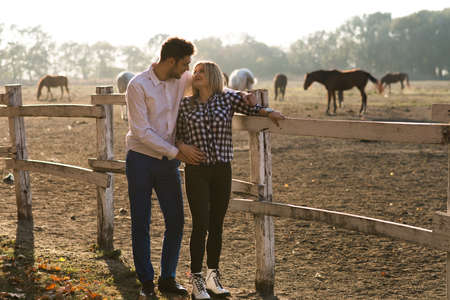 Couple in love enjoy day in nature and beautiful horsesの写真素材