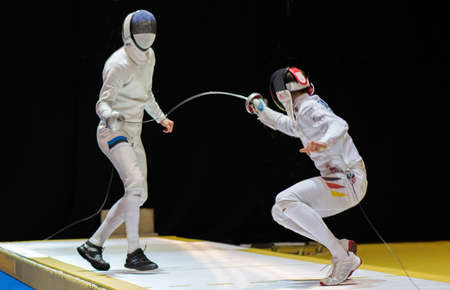 Two man fencing athletes fight on professional sports arena
