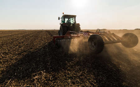 Tractors plowing stubble fields