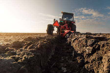 Tractors plowing stubble fields