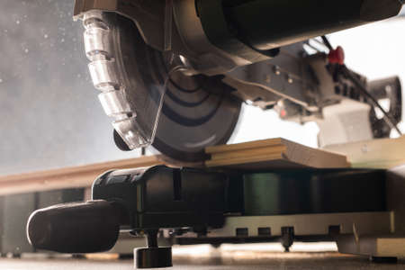 Modern electric circular saw in the workshop cutting woodの写真素材