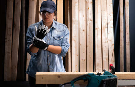Young woman  using modern electric  saw for ctting wood  in the workshopの写真素材